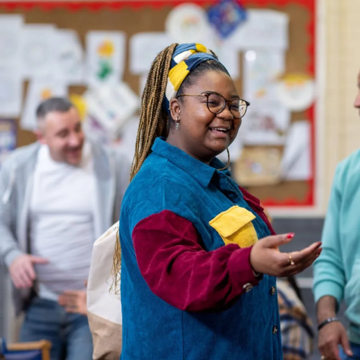 A group of adults greeting each other in a community centre