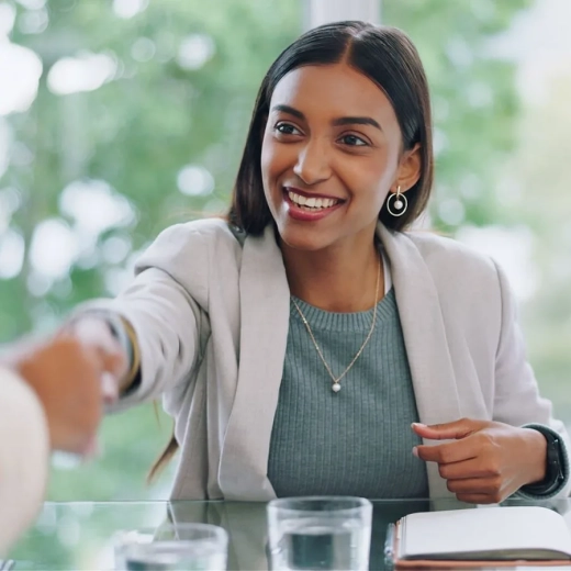 Business woman shaking hands in agreement in an office